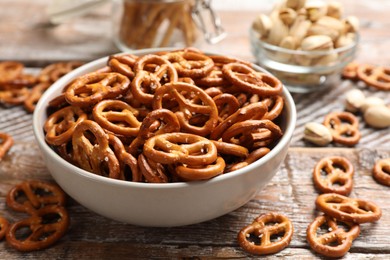 Photo of Delicious salty pretzel crackers on wooden table, closeup