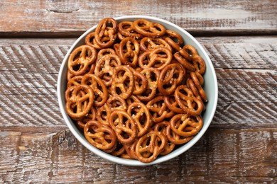 Photo of Delicious salty pretzel crackers on wooden table, top view