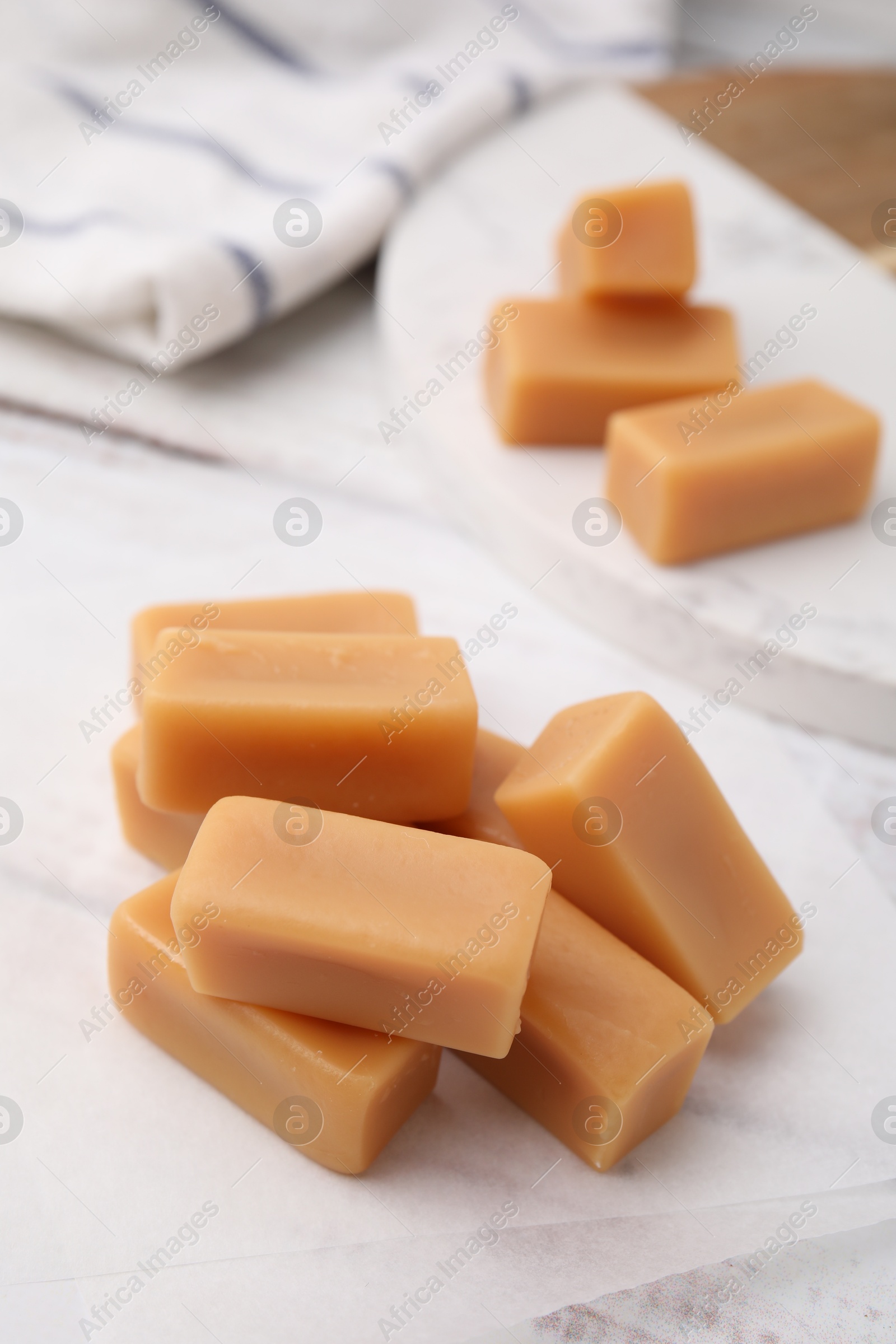 Photo of Tasty sweet caramel candies on white table, closeup