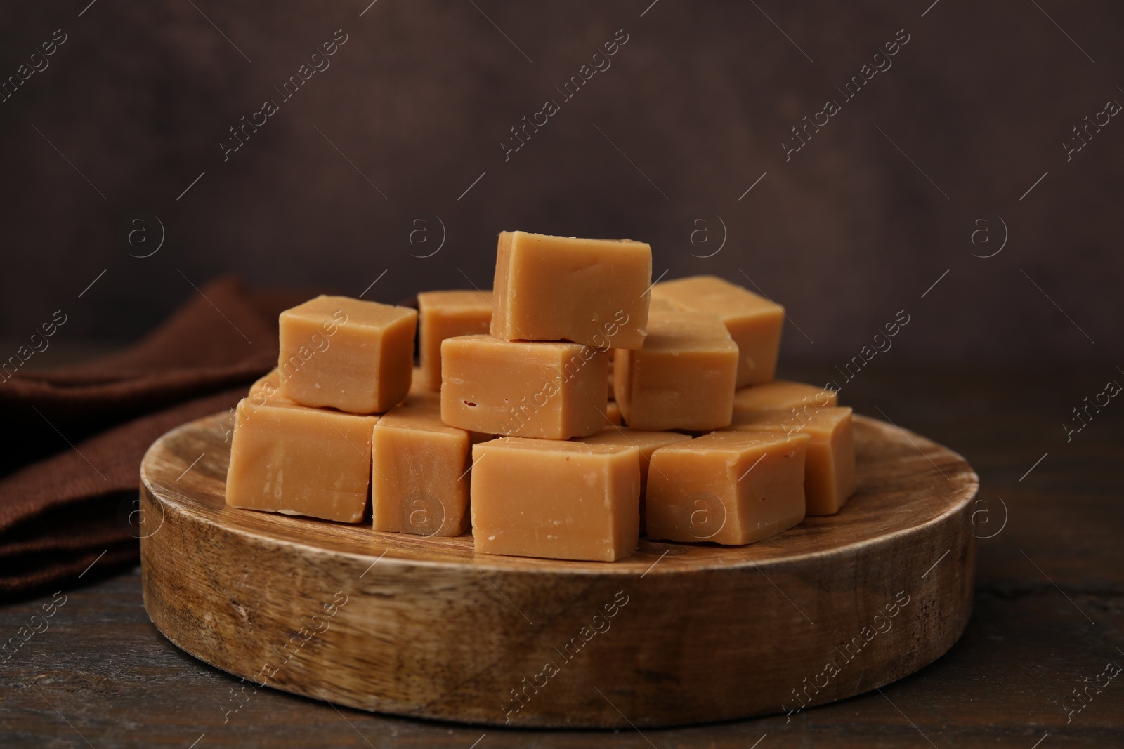 Photo of Tasty sweet caramel candies on wooden table, closeup