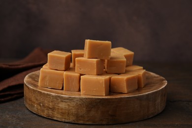 Photo of Tasty sweet caramel candies on wooden table, closeup