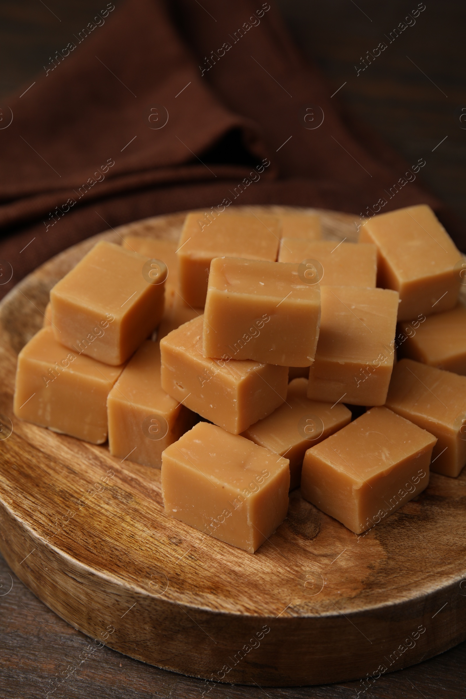 Photo of Tasty sweet caramel candies on wooden table, closeup