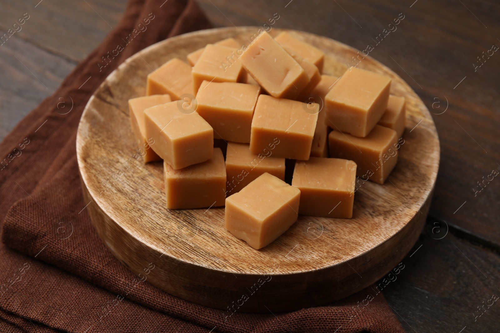 Photo of Tasty sweet caramel candies on wooden table, closeup