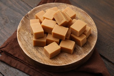 Photo of Tasty sweet caramel candies on wooden table, closeup