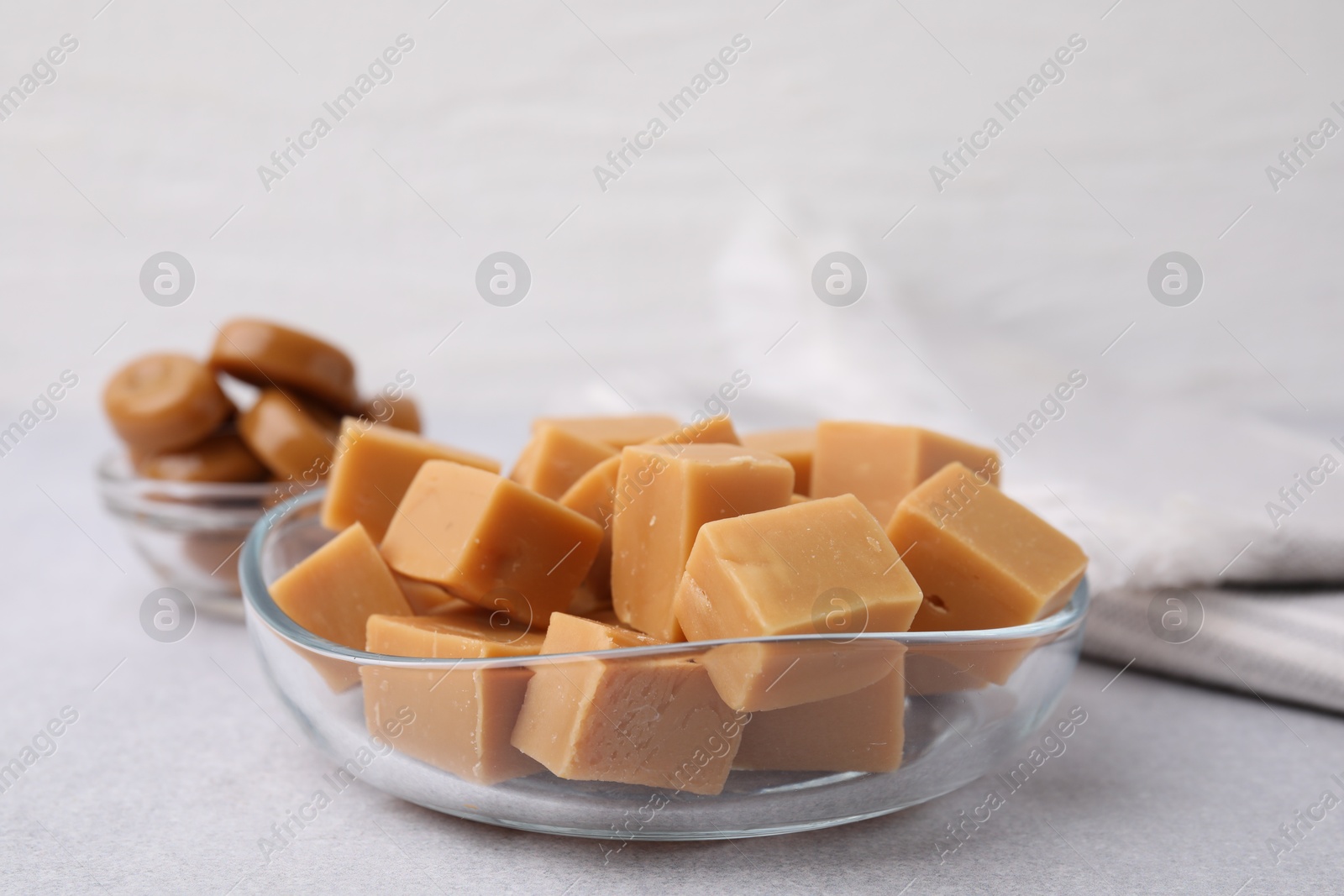 Photo of Tasty sweet caramel candies on light grey table, closeup