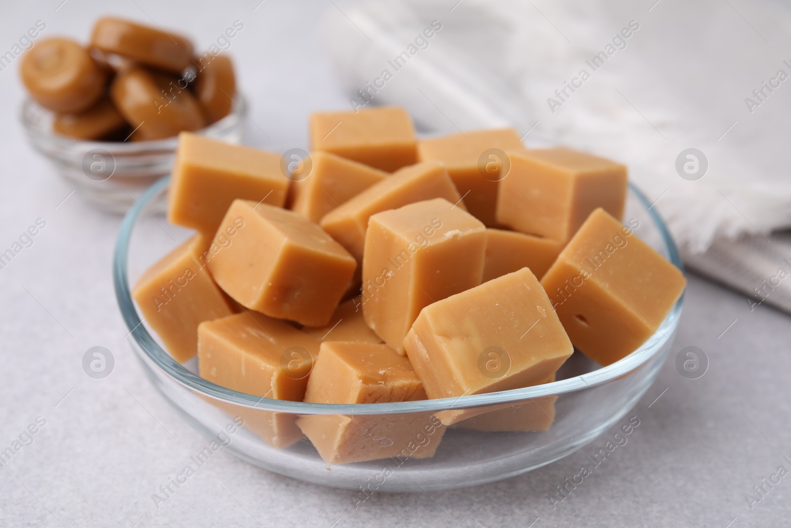 Photo of Tasty sweet caramel candies on light grey table, closeup