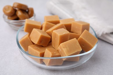 Photo of Tasty sweet caramel candies on light grey table, closeup