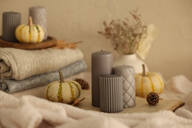 Photo of Grey candles and autumn decor indoors, closeup