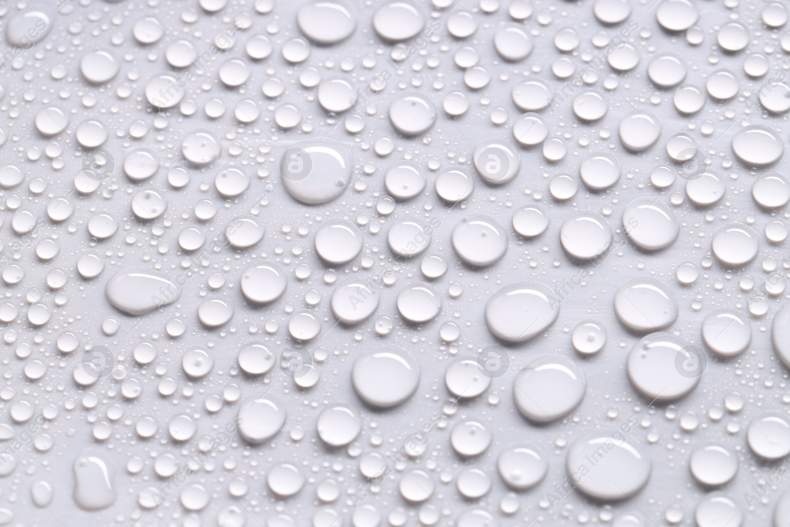 Photo of Water drops on light gray background, closeup view