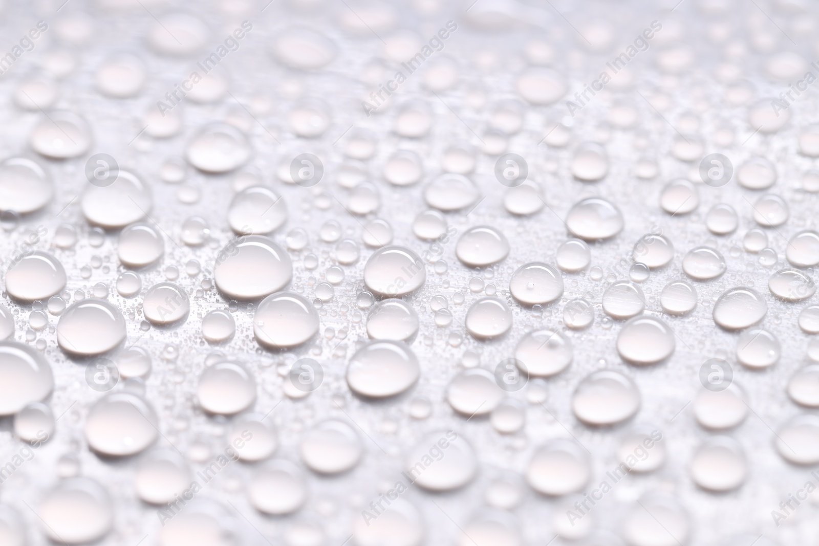 Photo of Water drops on light gray background, closeup view