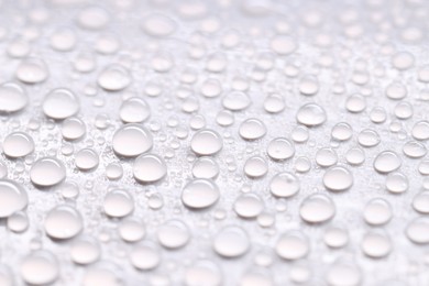 Photo of Water drops on light gray background, closeup view