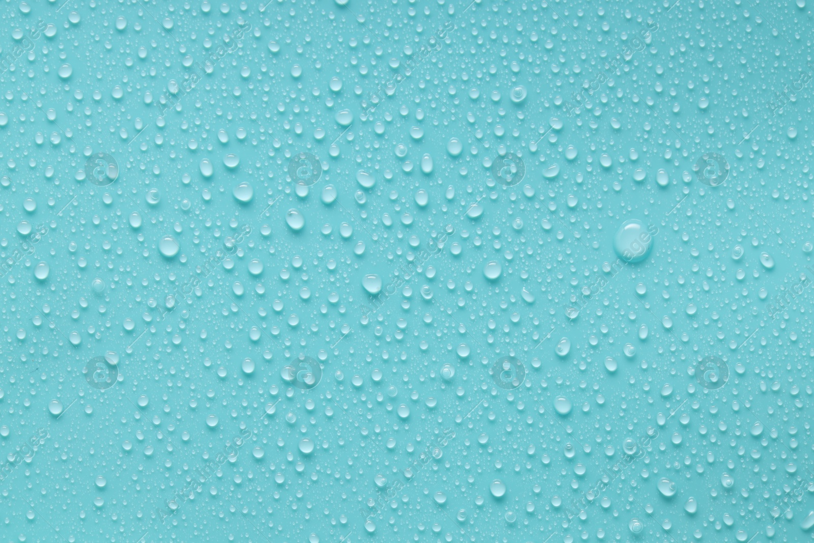 Photo of Water drops on turquoise background, above view