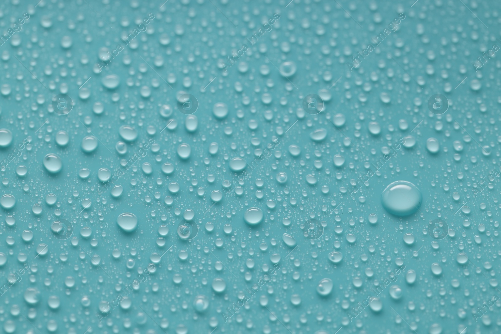 Photo of Water drops on turquoise background, above view