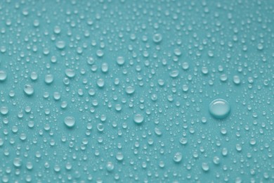 Photo of Water drops on turquoise background, above view