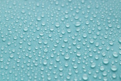 Photo of Water drops on turquoise background, above view