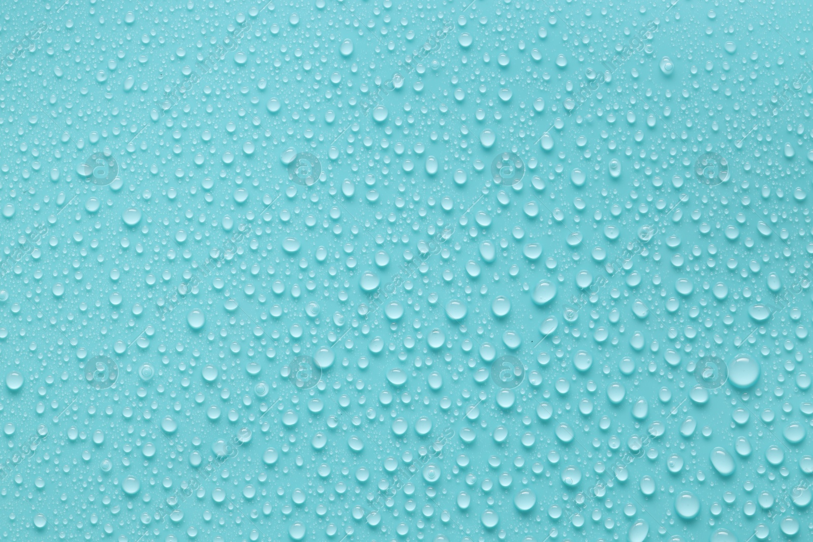 Photo of Water drops on turquoise background, above view