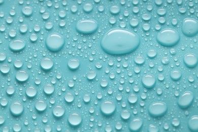 Photo of Water drops on turquoise background, above view