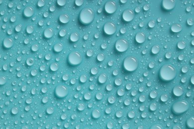 Photo of Water drops on turquoise background, above view