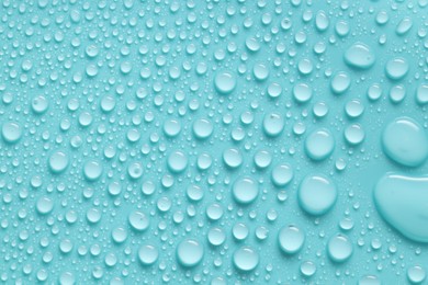 Photo of Water drops on turquoise background, above view