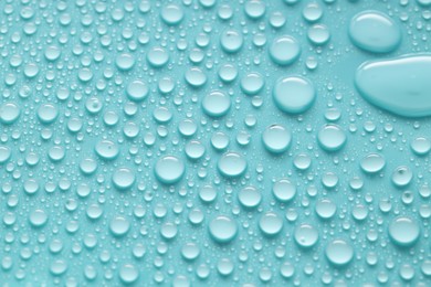 Photo of Water drops on turquoise background, above view