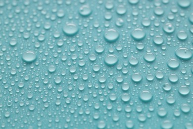 Photo of Water drops on turquoise background, above view