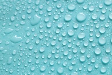 Photo of Water drops on turquoise background, above view