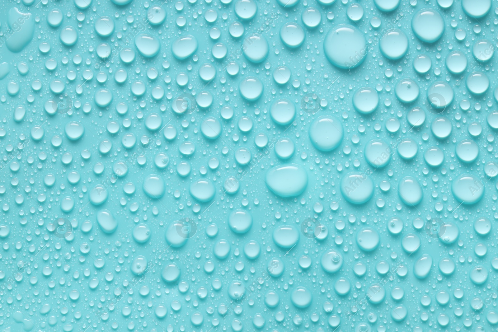 Photo of Water drops on turquoise background, above view