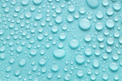 Photo of Water drops on turquoise background, above view