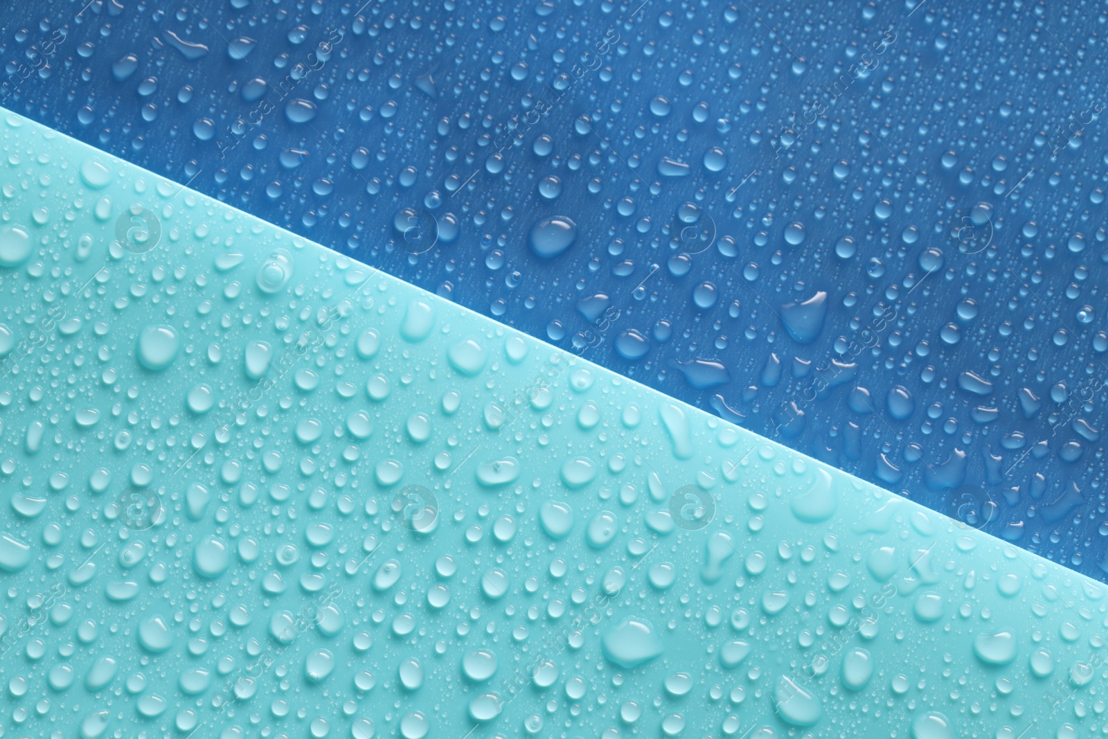 Photo of Water drops on color background, above view