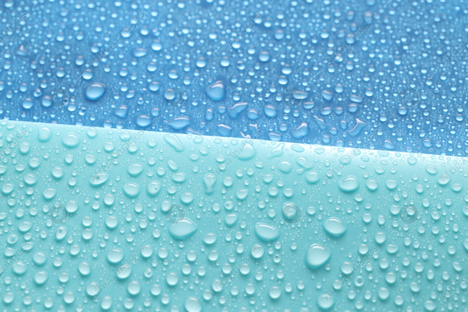 Photo of Water drops on color background, above view