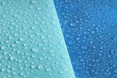 Photo of Water drops on color background, above view