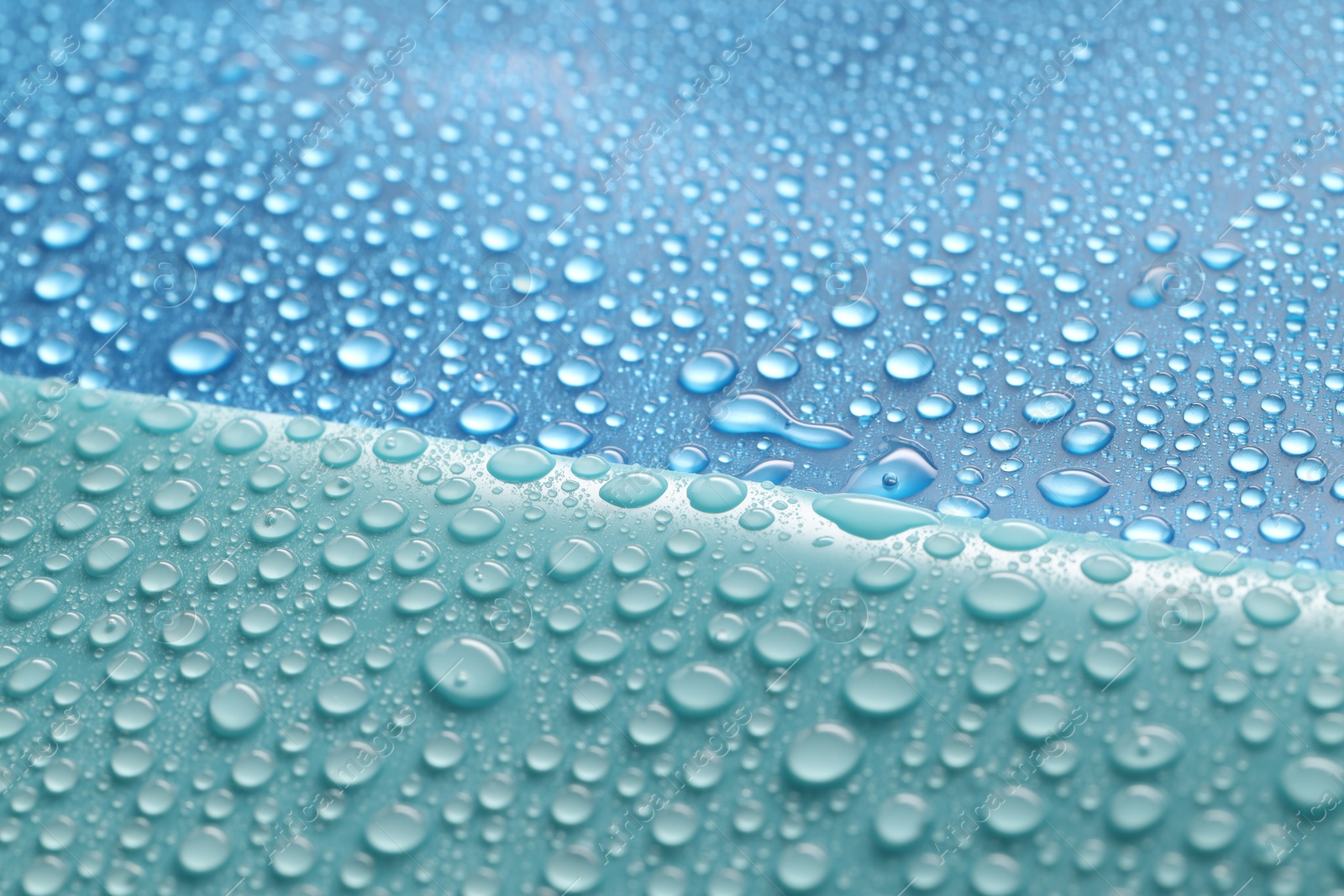 Photo of Water drops on color background, above view