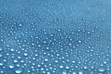 Photo of Water drops on blue background, closeup view