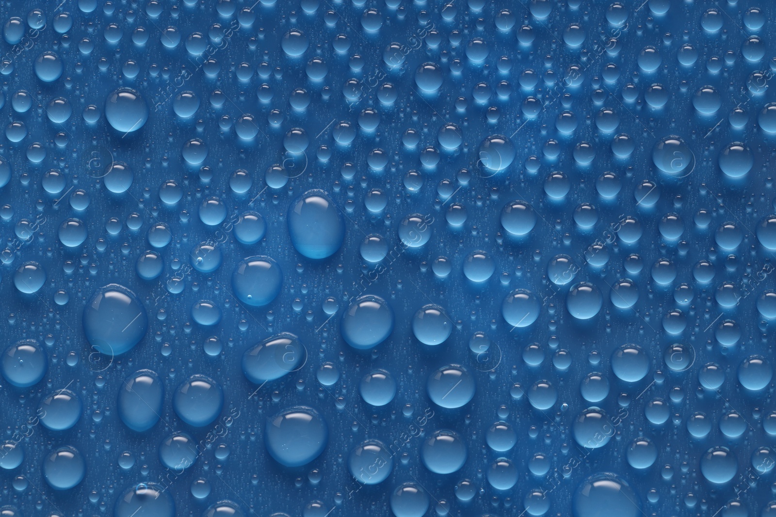 Photo of Water drops on blue background, above view