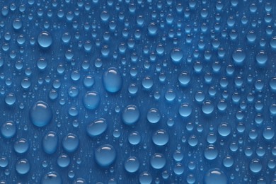 Photo of Water drops on blue background, above view