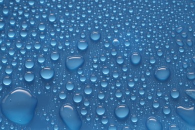 Photo of Water drops on blue background, above view