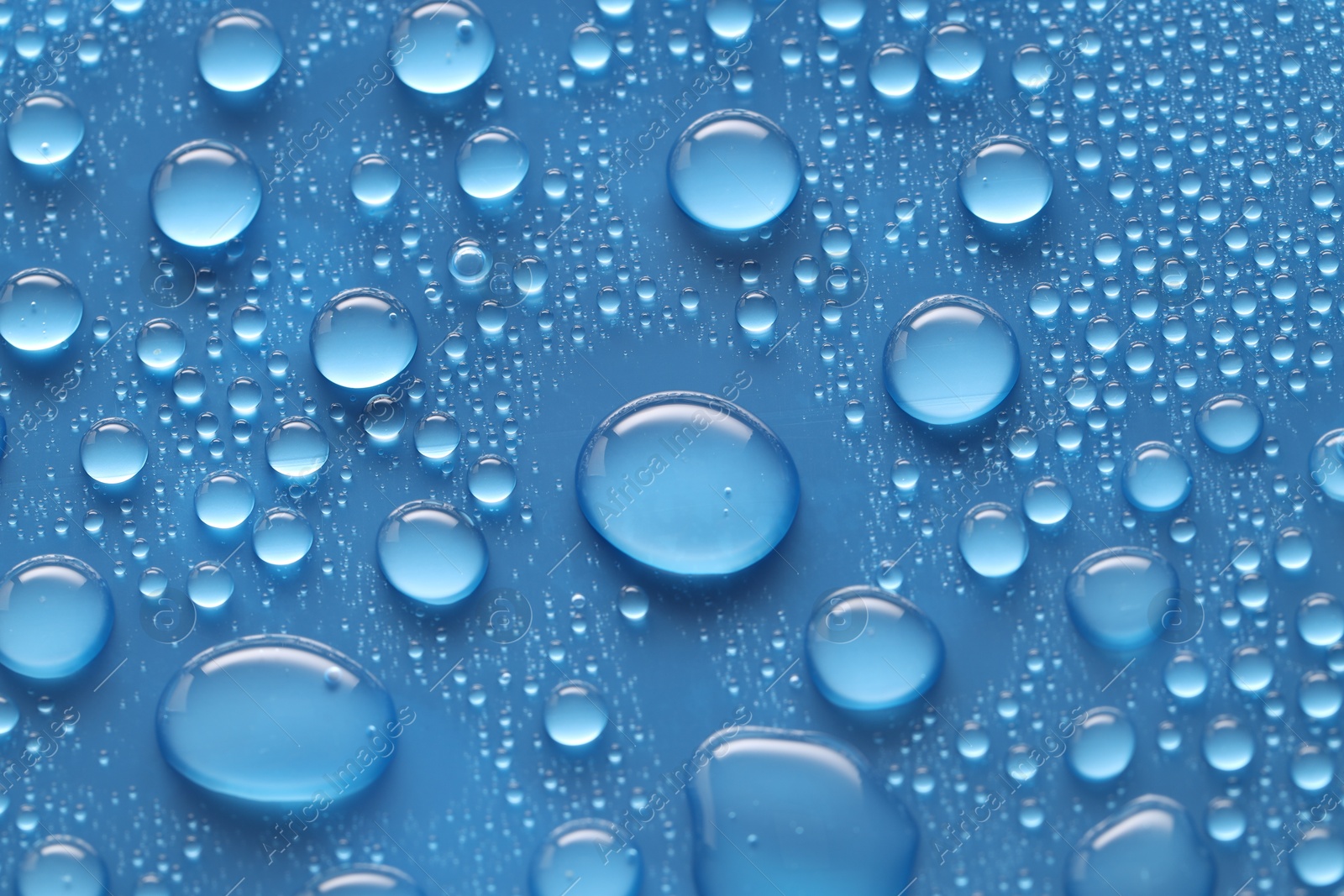 Photo of Water drops on blue background, above view