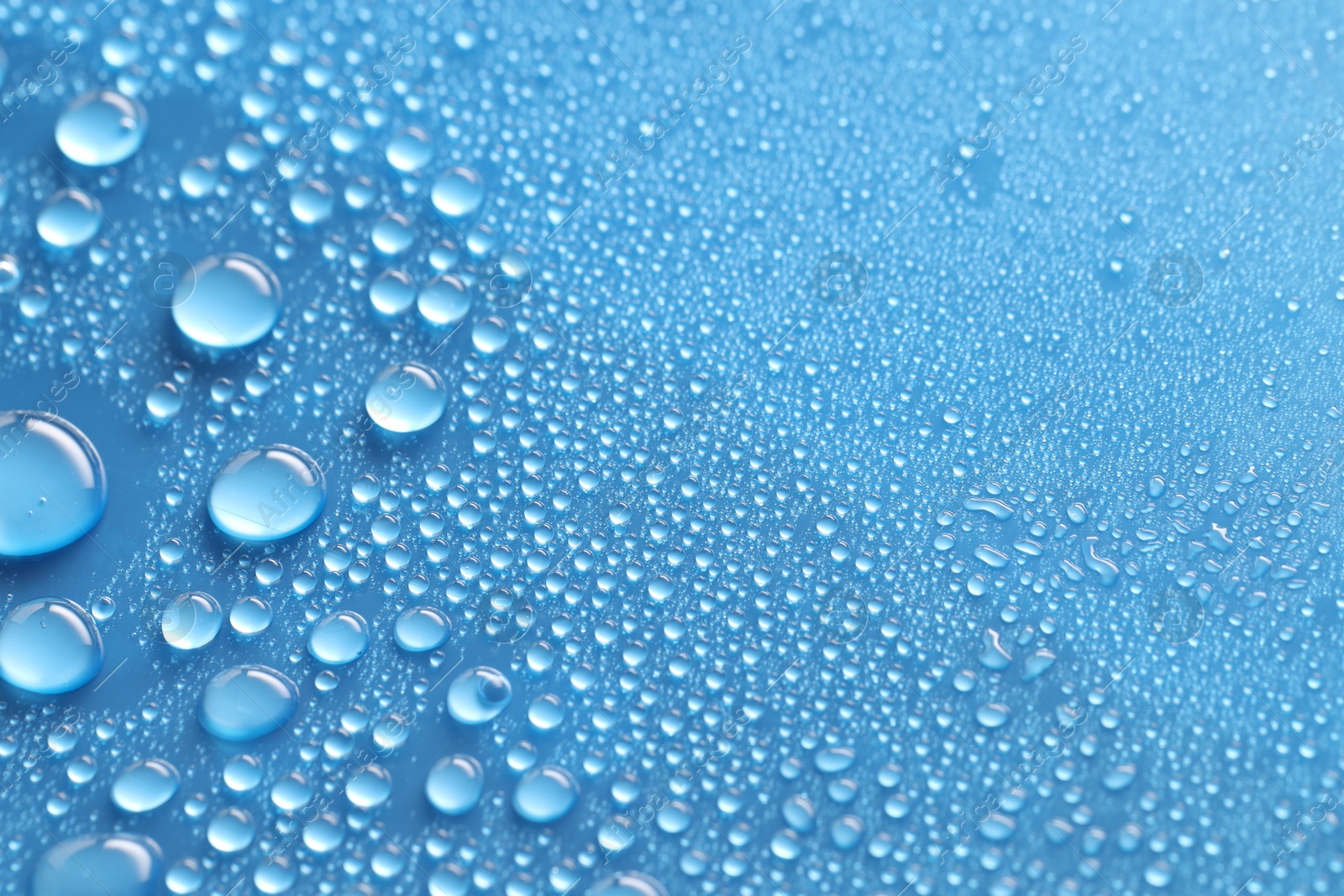 Photo of Water drops on blue background, above view