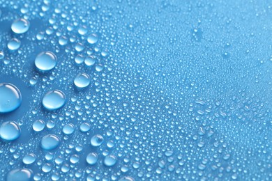 Photo of Water drops on blue background, above view