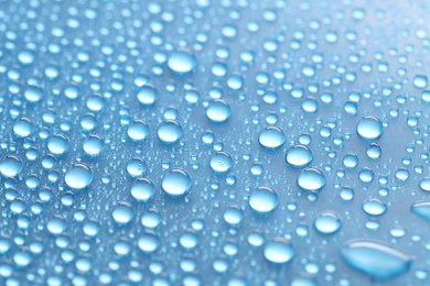 Photo of Water drops on light blue background, above view