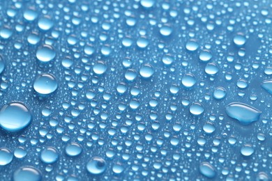 Photo of Water drops on blue background, above view