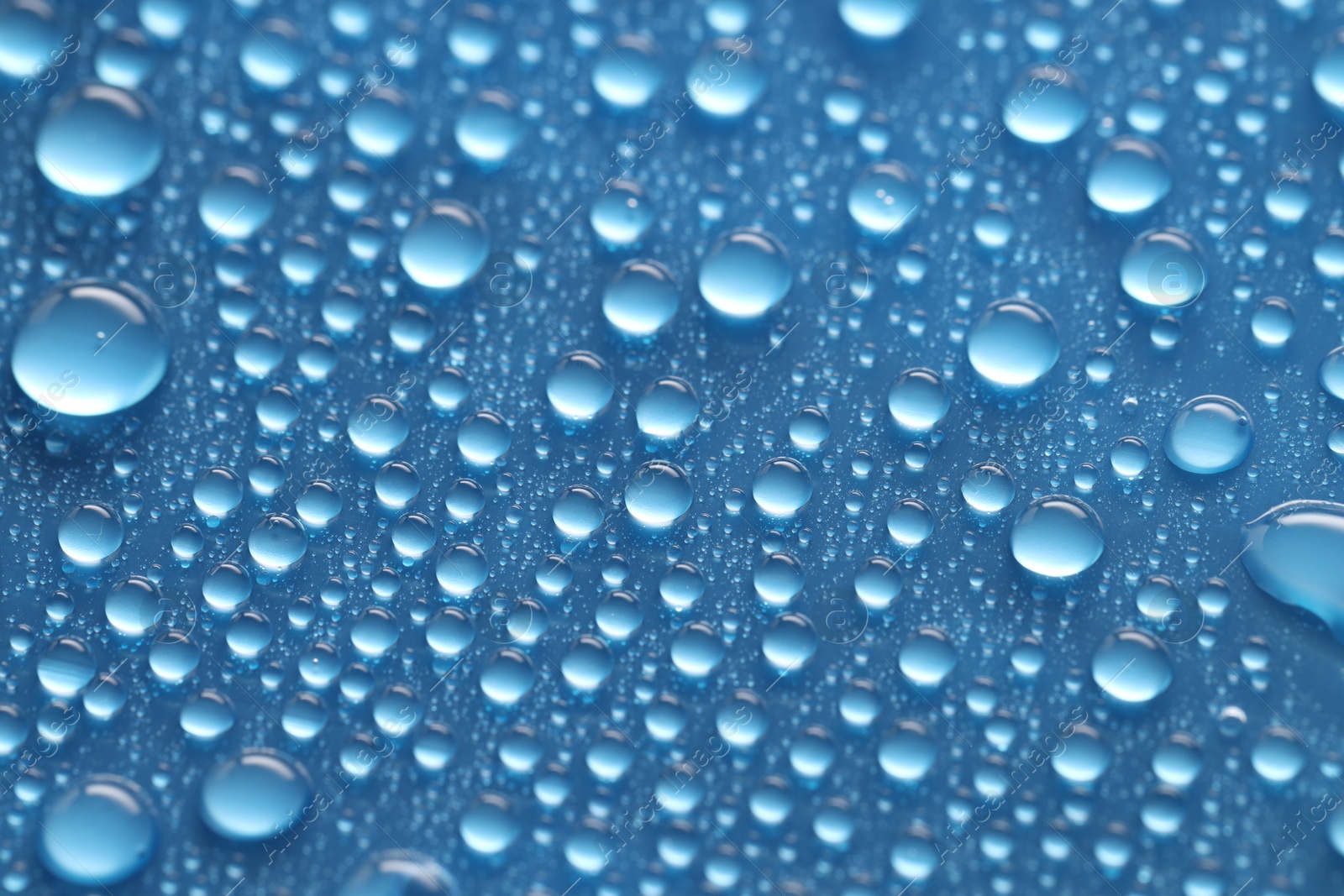 Photo of Water drops on blue background, above view