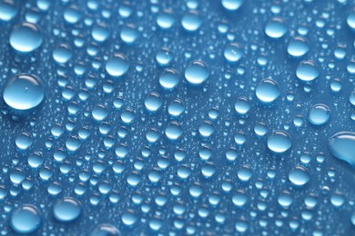 Photo of Water drops on blue background, above view