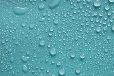 Photo of Water drops on turquoise background, above view