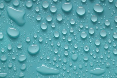 Photo of Water drops on turquoise background, above view