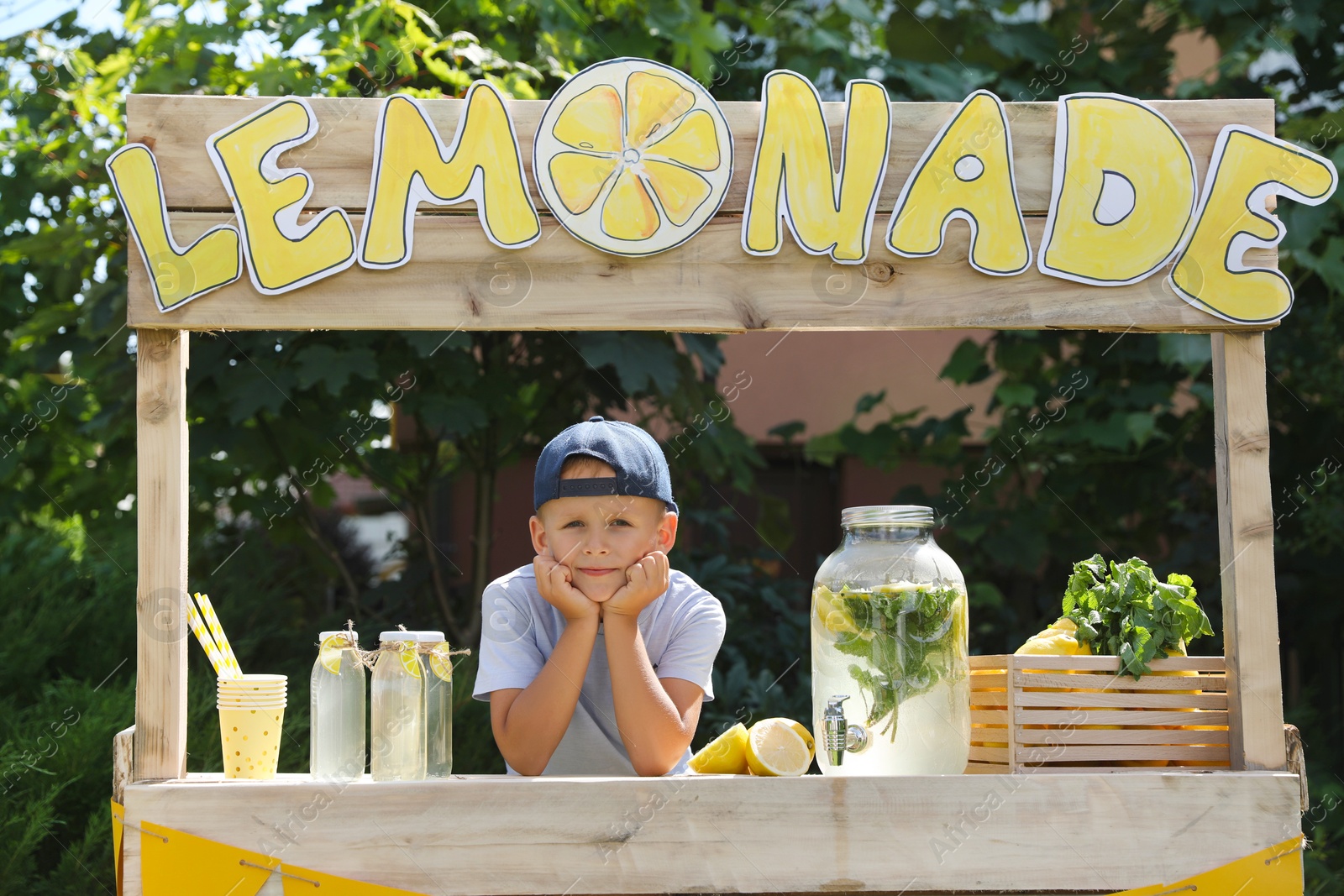 Photo of Cute little boy at lemonade stand in park