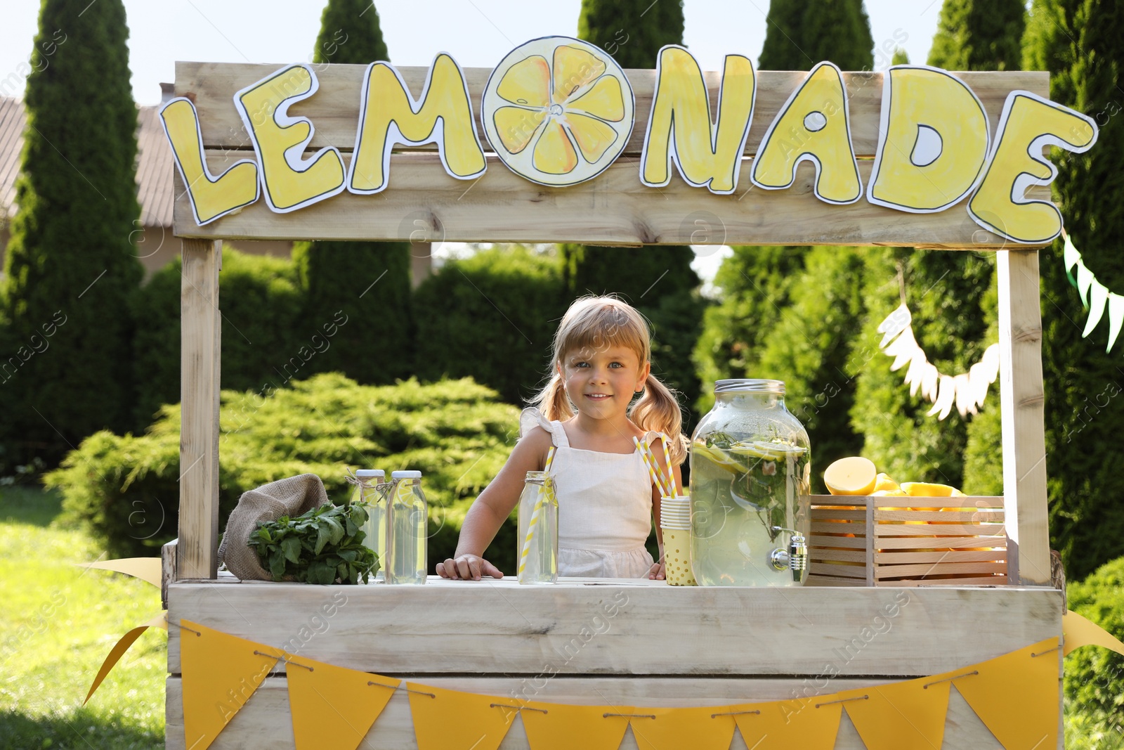 Photo of Cute little girl at lemonade stand in park