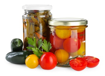 Photo of Tasty pickled vegetables in jars and fresh ingredients isolated on white