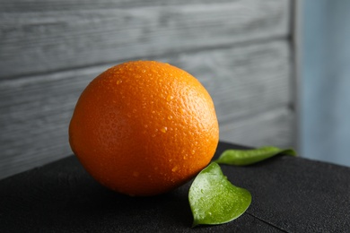 Photo of Fresh orange with leaves on table, closeup