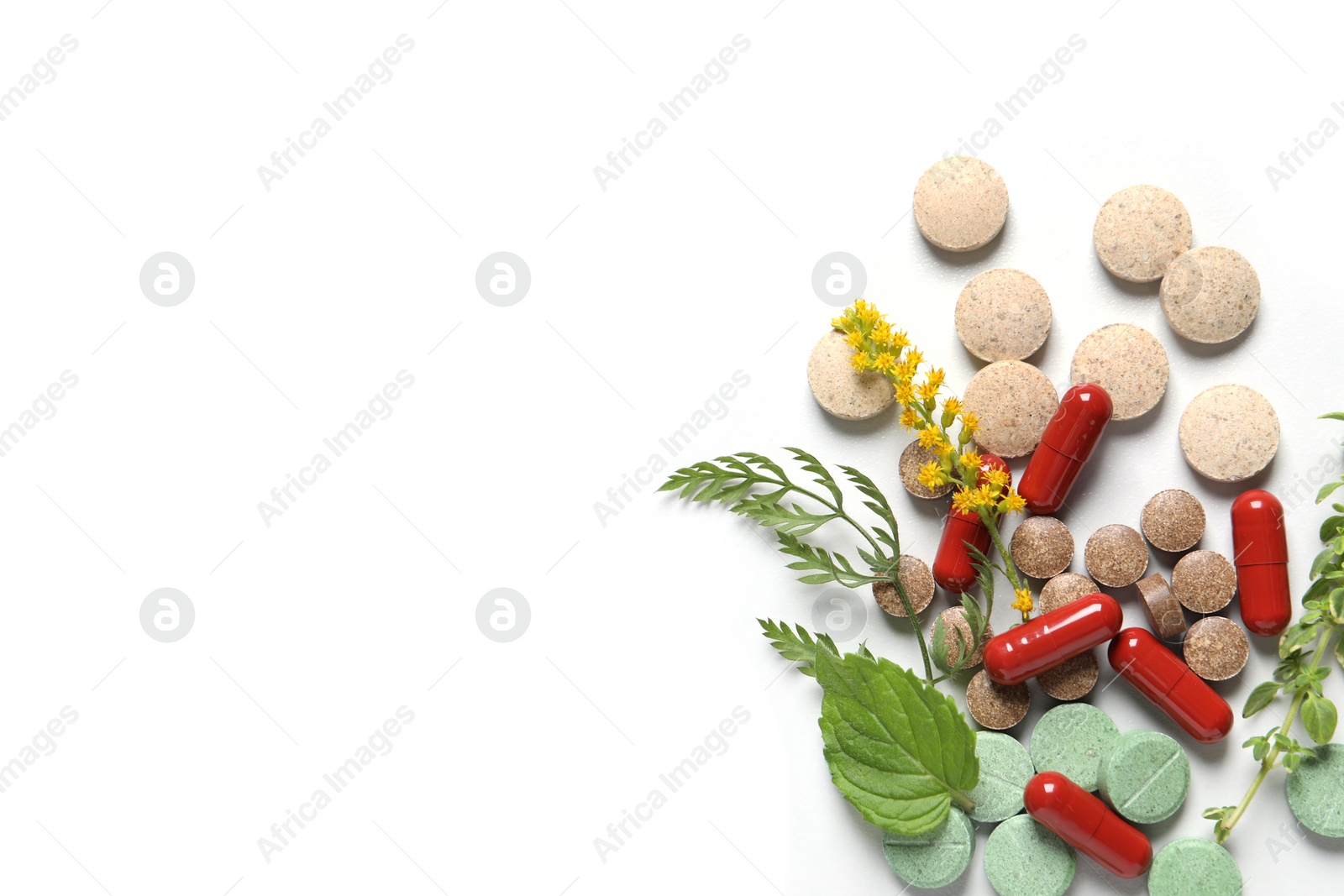 Photo of Different pills and herbs on white table, flat lay with space for text. Dietary supplements